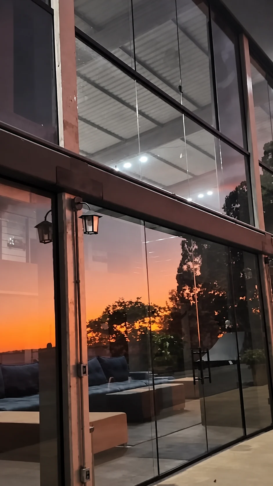 O pôr do sol refletido na fachada de vidro da sede do Instituto Liberdade